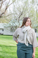 Woman wearing a three-color (white, green and blue) hand knit scarf